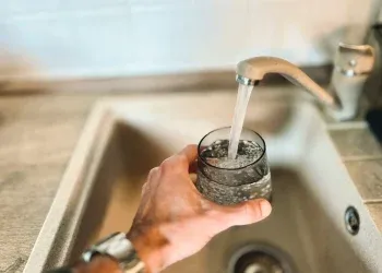 a hand holding a glass of water