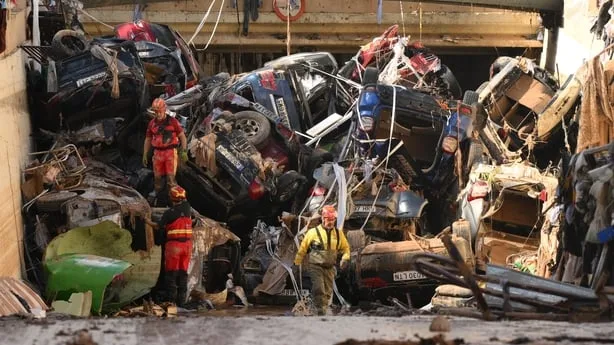 Members of the fire brigade carry out work as cars and debris block a tunnel near the Benetusser municipality